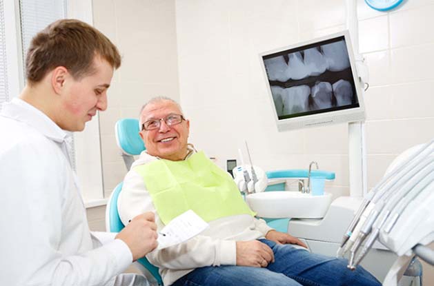 Dentist explaining cost of dentures in East Longmeadow and Northampton