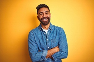 man against orange background smiling