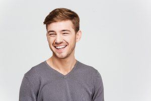 man in gray sweater smiling