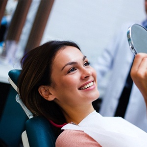 Patient looking at smile in dental mirror