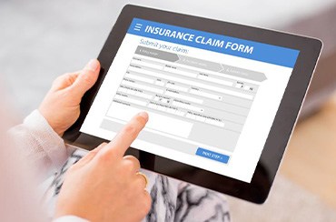 Person filling out insurance claim form on tablet