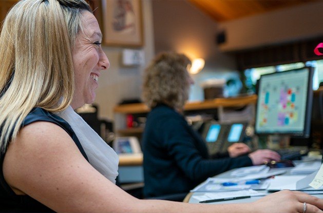 front desk workers smiling at computer