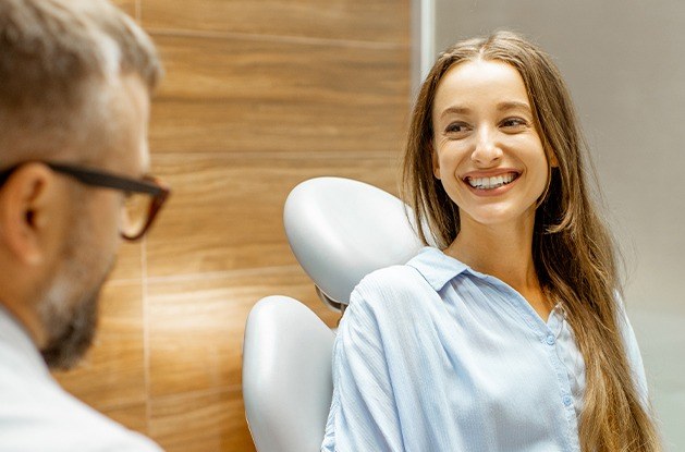 woman in blue hsirt smiling at dentist