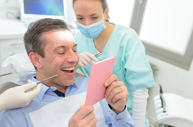 patient looking at dental bridge in East Longmeadow