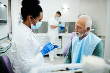 A dentist talking with a patient about dentures