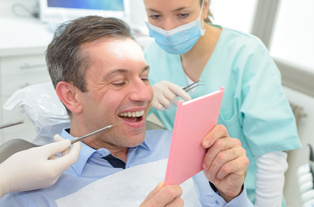 man checking smile in mirror