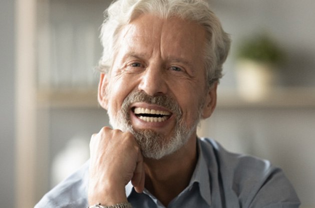 A closeup of an elderly man wearing dentures