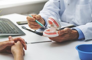 A patient discussing denture care with their dentist