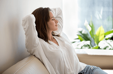 a woman with dentures relaxing on a couch 