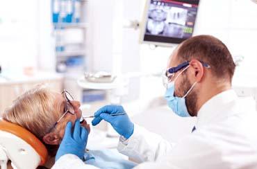 Denture dentist in East Longmeadow and Northampton examining a patient