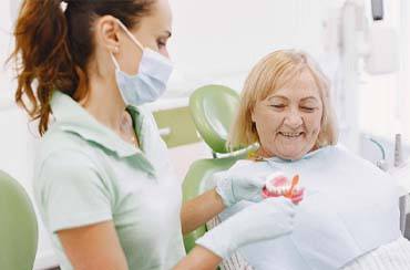 Dentist explaining care for dentures in East Longmeadow and Northampton