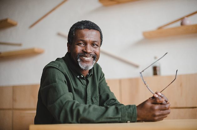 man smiling while holding glasses