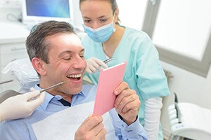 man checking smile in pink mirror