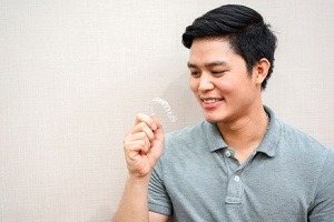 man looking at invisalign tray