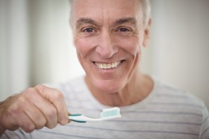 older man brushing teeth