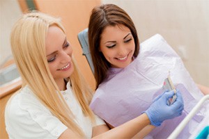 two woman looking at implant chart