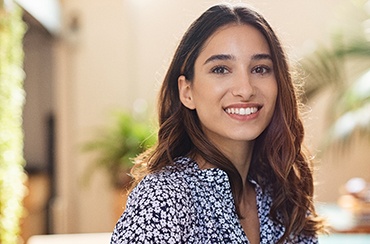 Woman in flowered shirt smiling with dental implants in Northampton, MA