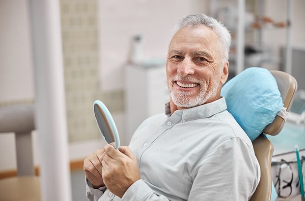 A happy elderly man sitting in a dentist’s chair