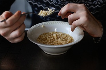 A man eating noodle soup at a table