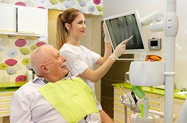 Implant dentist in East Longmeadow and Northampton showing patient an X-ray