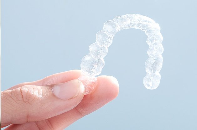 fingers holding invisalign tray