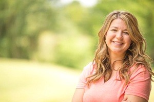 woman in peach shirt smiling