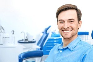 man smiling in blue jean shirt