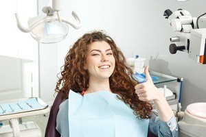 woman with curly hair doing thumbs up