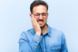 man with glasses in severe pain