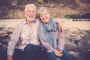 man and woman sitting on rocks