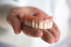hand holding top denture