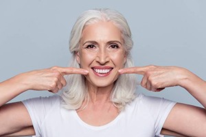 woman with white hair pointing to smile