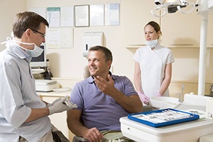 man in purple shirt talking to dentist