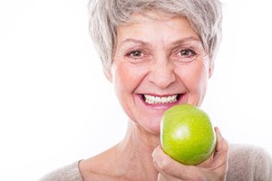 older woman holding apple