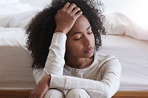 woman sitting neck to bed tired