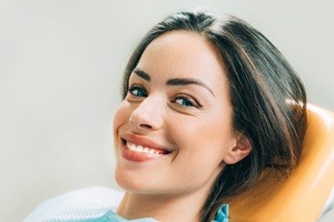 woman smiling on orange exam chair