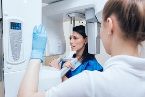 woman biting down on cone beam scanner