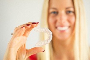 woman holding invisalign with cupped hand
