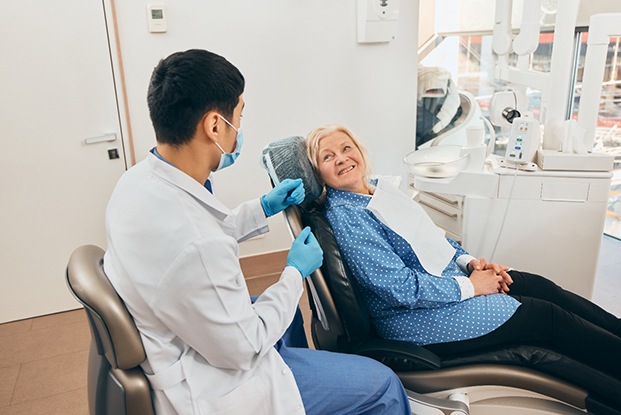 Smiling senior patient talking with her dentist