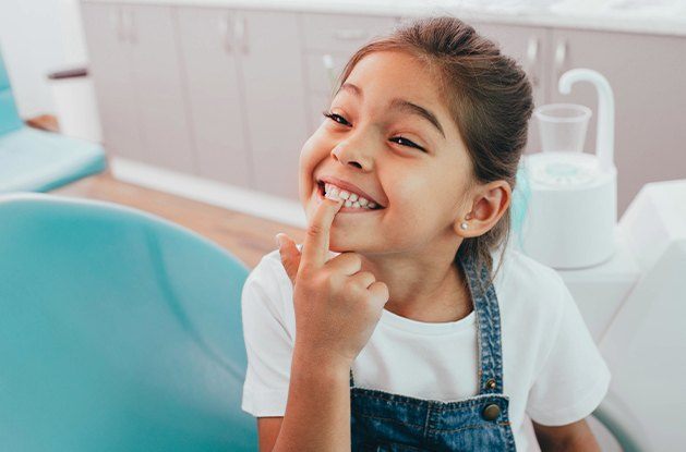 young girl pointing to teeth