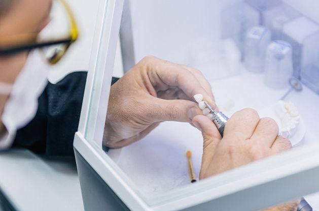 prosthodontist working on dental bridge