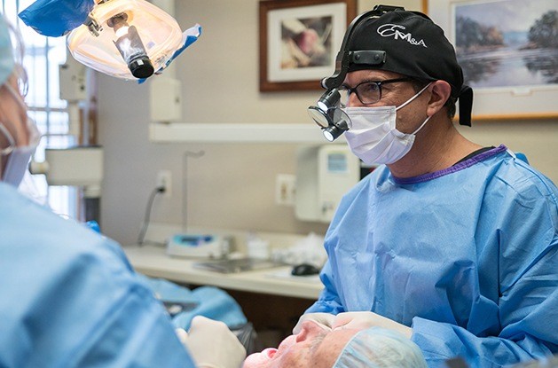 prosthodontist with protective gear on