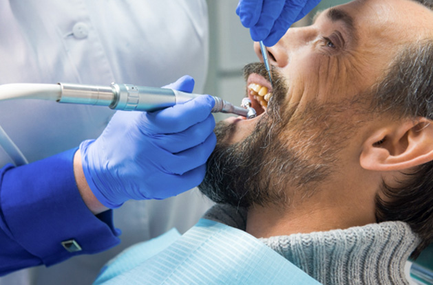 a man receiving a deep cleaning at a dental office