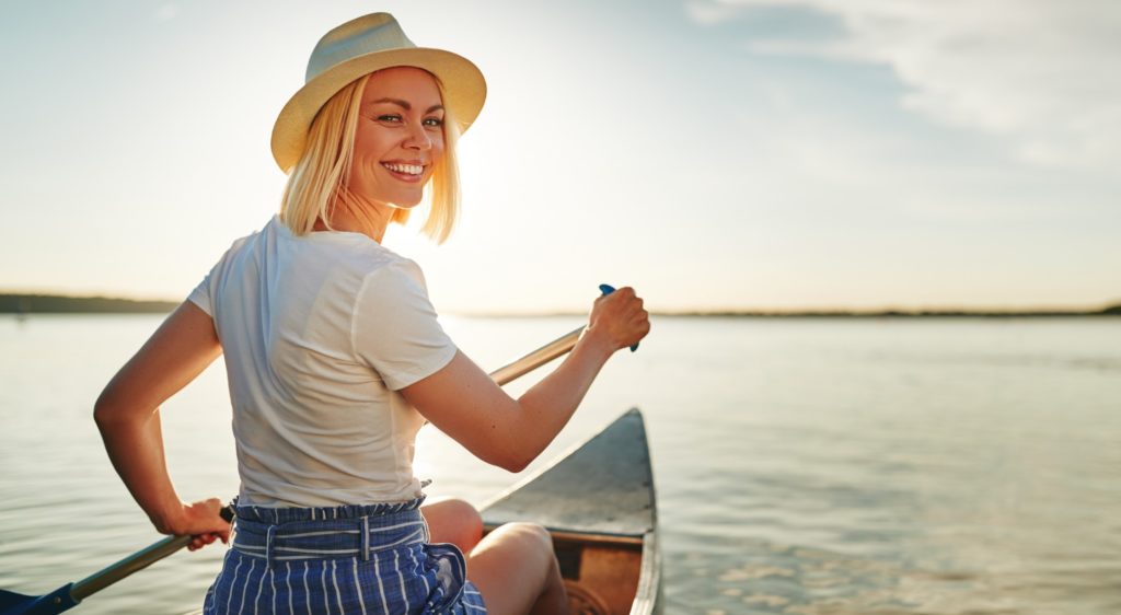 Woman smiling while kayaking on the lake