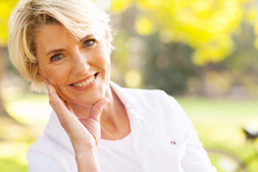 Woman smiling after her All-on-4 surgery.