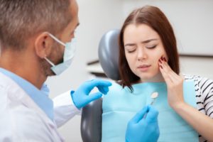 a woman visiting her emergency dentist to get help for her facial pain