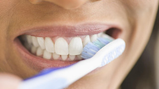 person using toothpaste for veneers to brush teeth