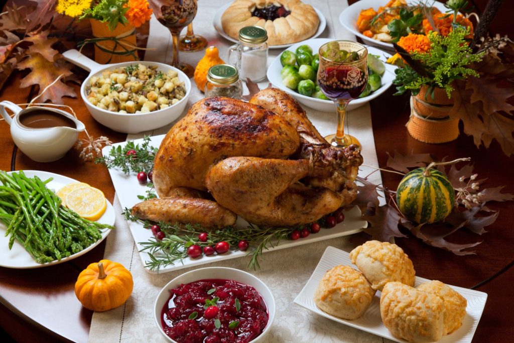 Table filled with Thanksgiving sides and turkey
