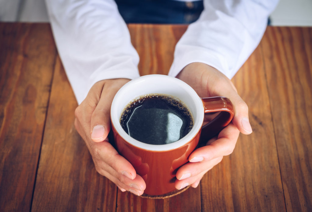 hands holding a cup of coffee 